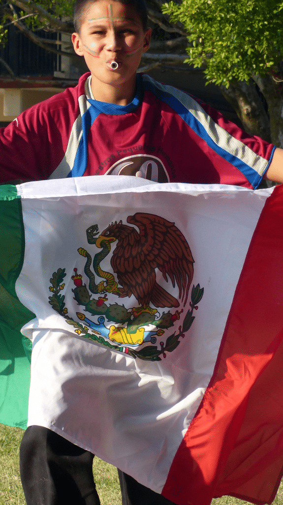 Lächelnder Junge in Mexiko mit einer mexikanischen Flagge