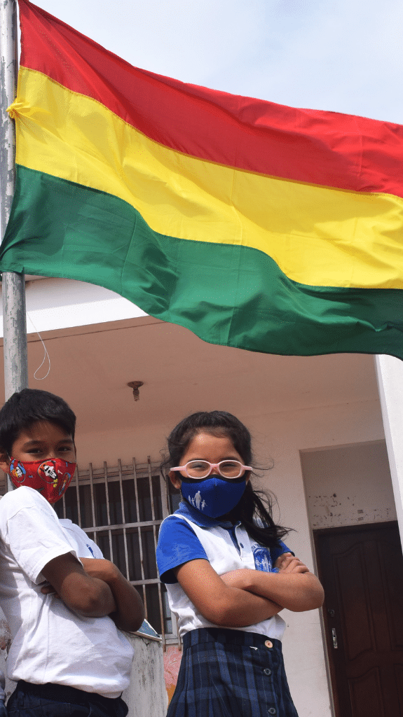 NPH Kinderpatenschaft für Bolivien, Mädchen hält eine bolivienische Flagge in der Hand.
