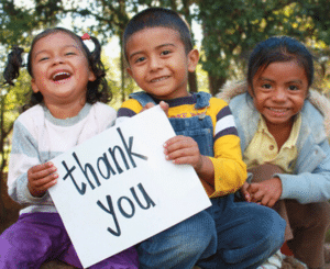 Kinder halten gemeinsam ein Thank-You-Schild in die Höhe.